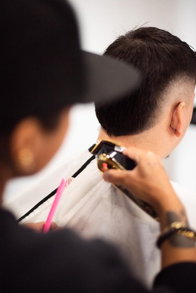 A Salon Fusion barber fading a client's haircut